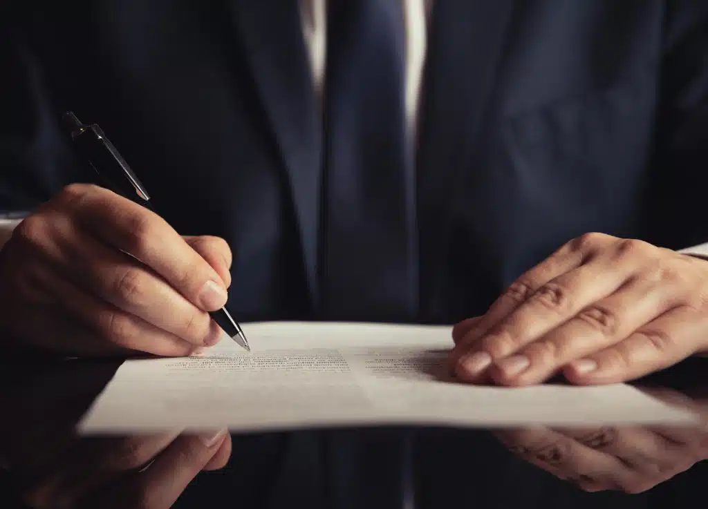 Close-up of business professional signing documents, symbolizing trust, operational precision, and strategic growth for professional service firms.